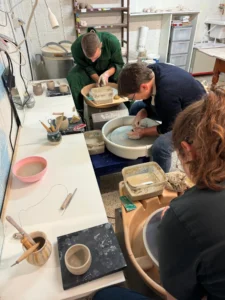 atelier de poterie à Waterloo avec participants créant des pièces en céramique au tour